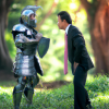 DALL·E 2022-09-30 18.44.23 - photo of a knight in armor facing a businessman wearing a suit standing outside