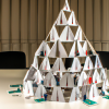 DALL·E 2022-09-30 18.37.28 - photo of a house of cards built from human beings in an office setting