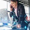 Businessman in suit has conference call to hire new employees for international business consulting. HR, social media hologram icons and interconnections over office background with panoramic windows